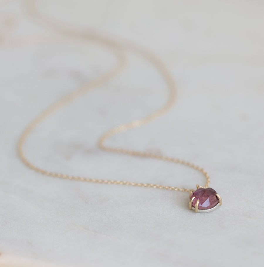 Necklace with a purple gemstone pendant on a light background