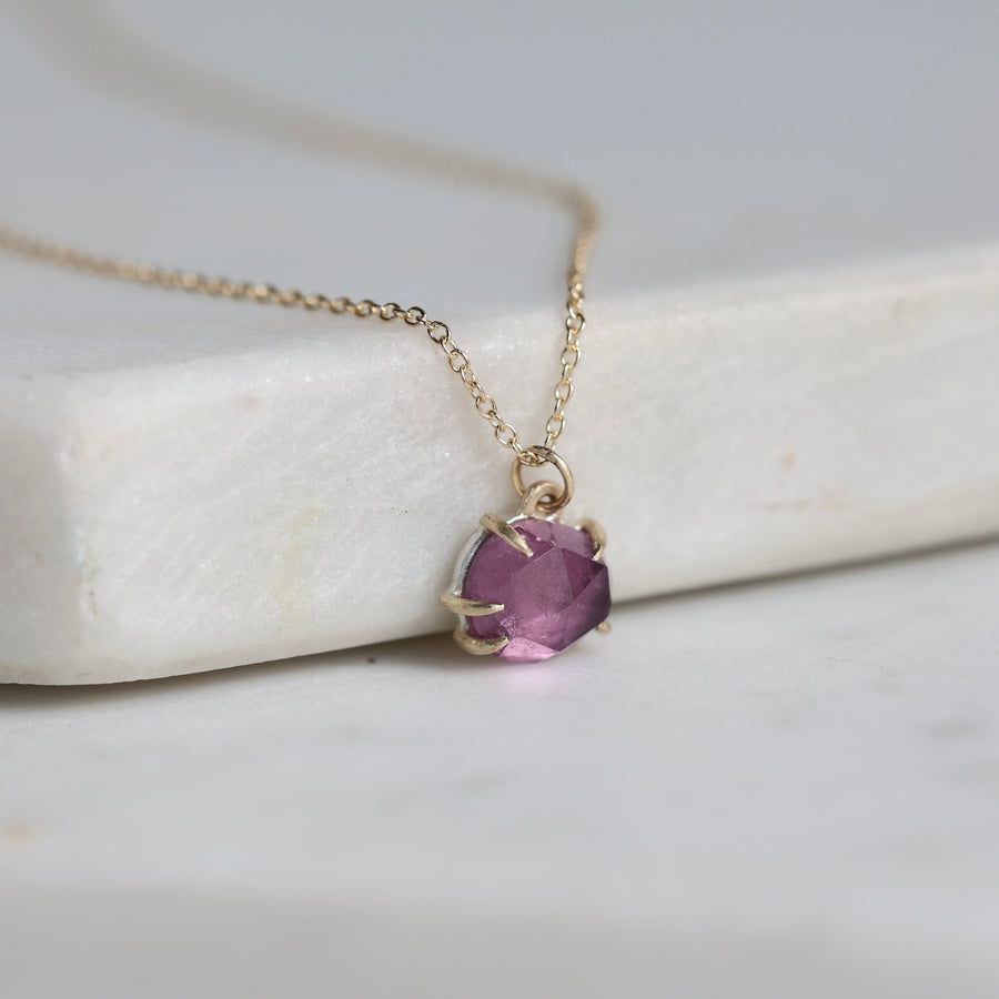 Necklace with a purple gemstone pendant on a white surface