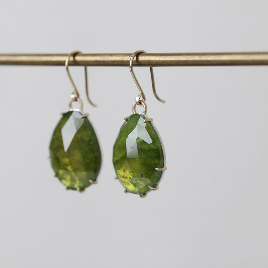 Green teardrop earrings on a gray background