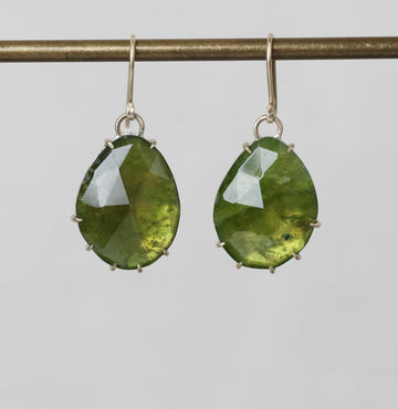 Green teardrop earrings on a gray background