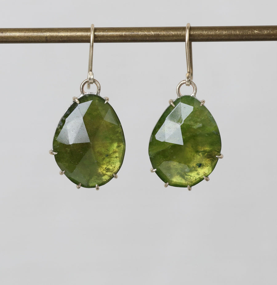 Green teardrop earrings on a gray background