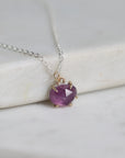 Necklace with a purple gemstone pendant on a marble surface