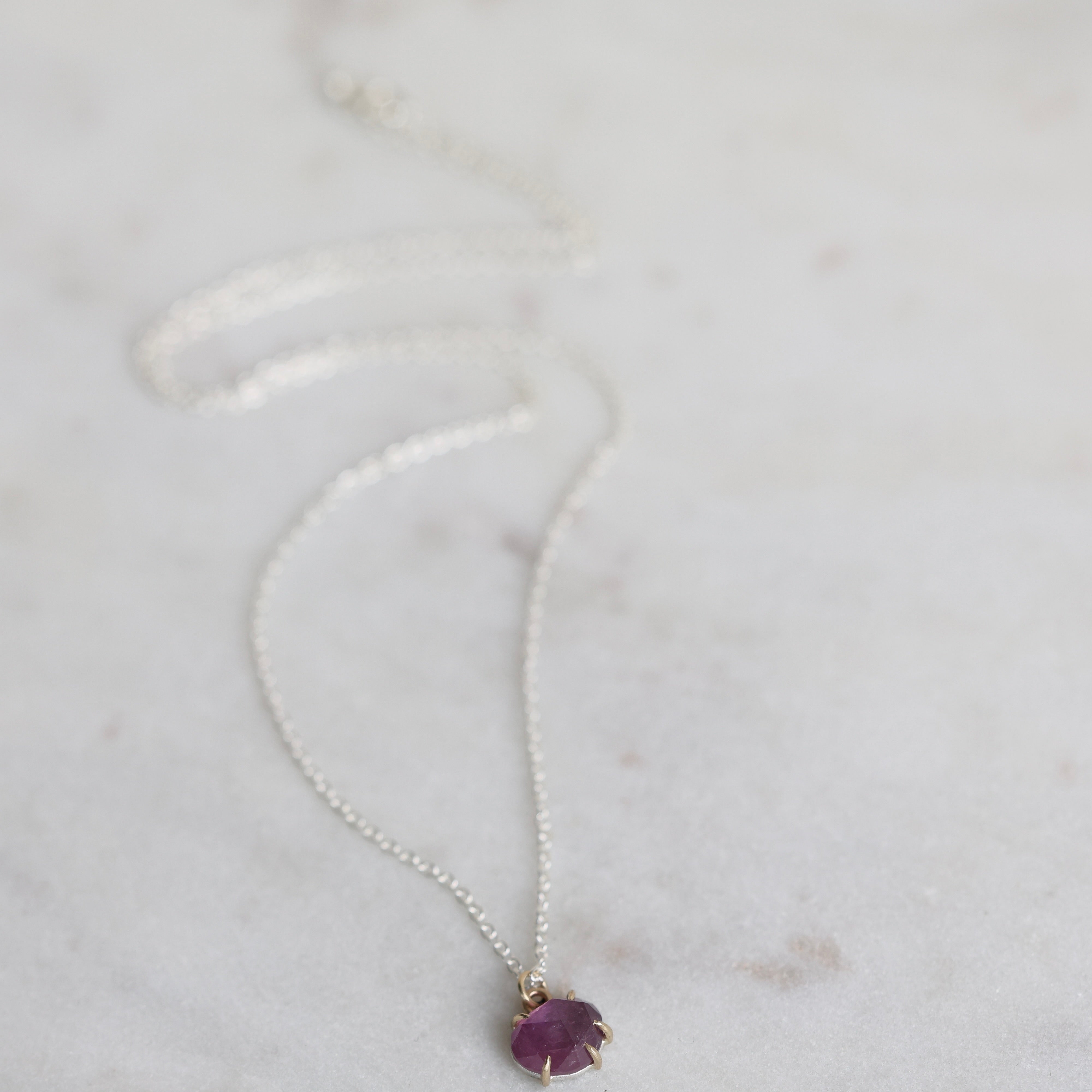 Purple stone necklace on a marble background 