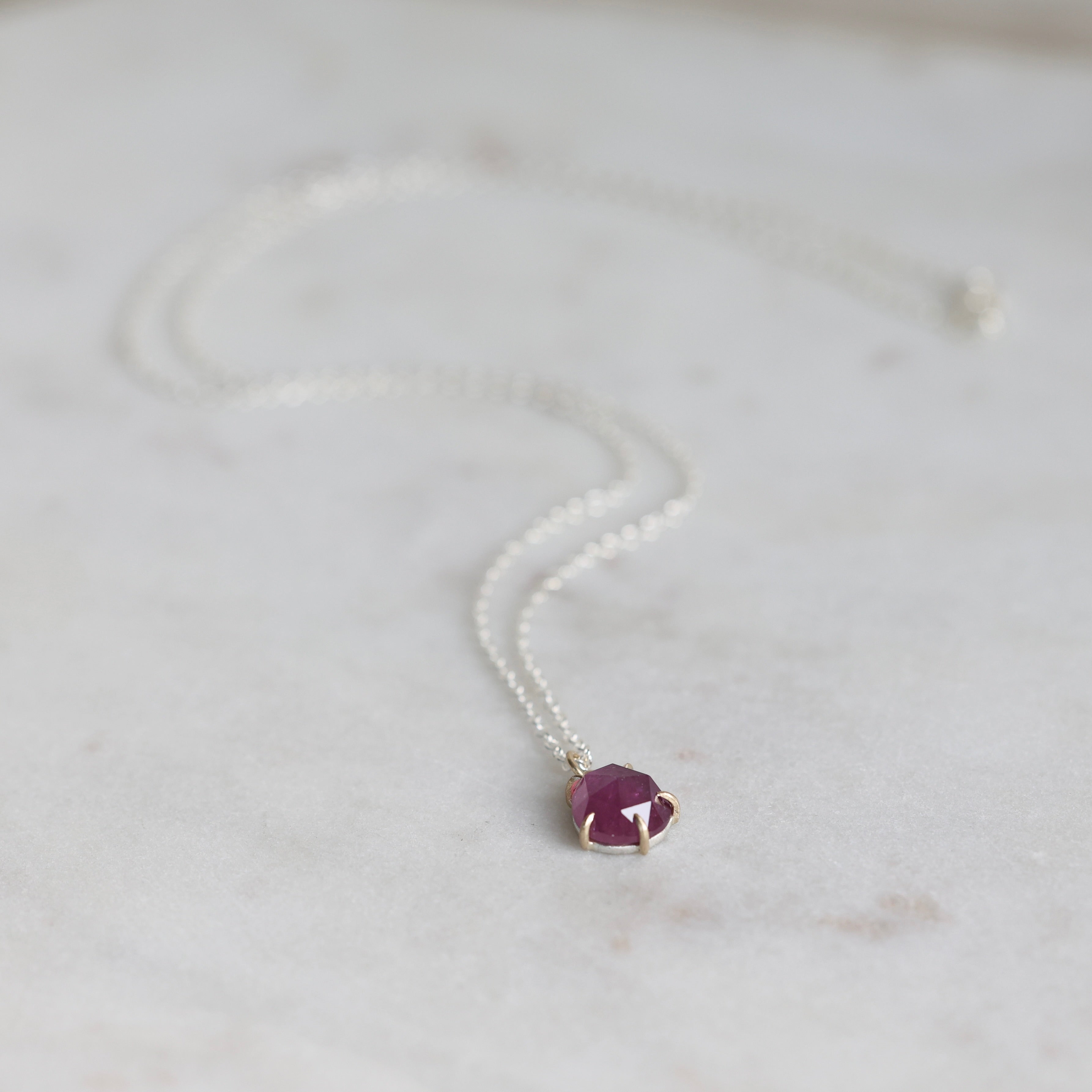 Necklace with a purple gemstone pendant on a light background