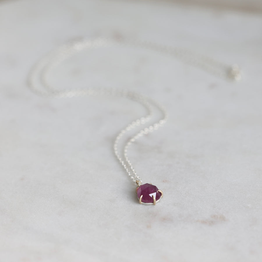 Necklace with a purple gemstone pendant on a light background
