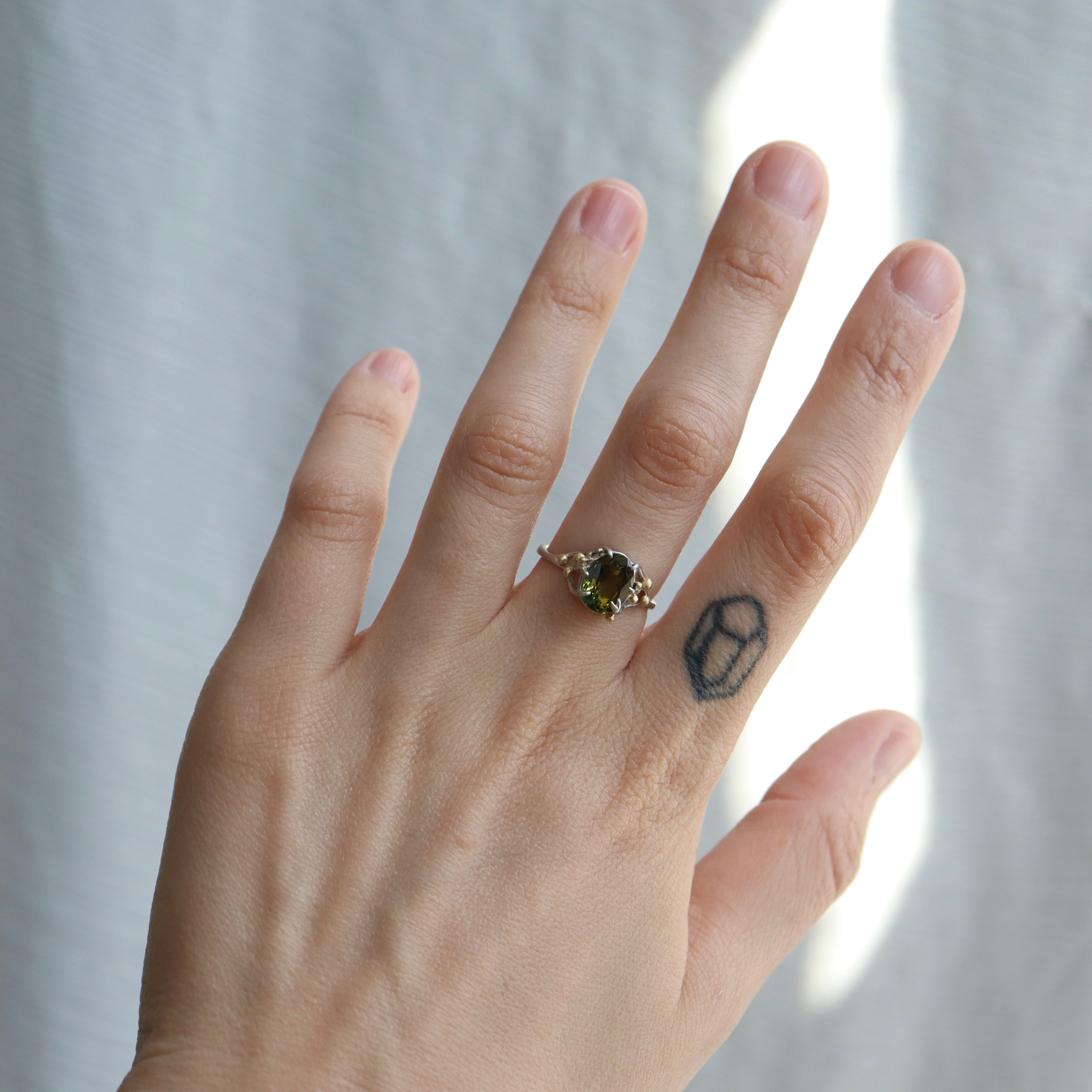 2.07ct Tourmaline waiting ring set in platinum with 18k gold berries, displayed on hand.