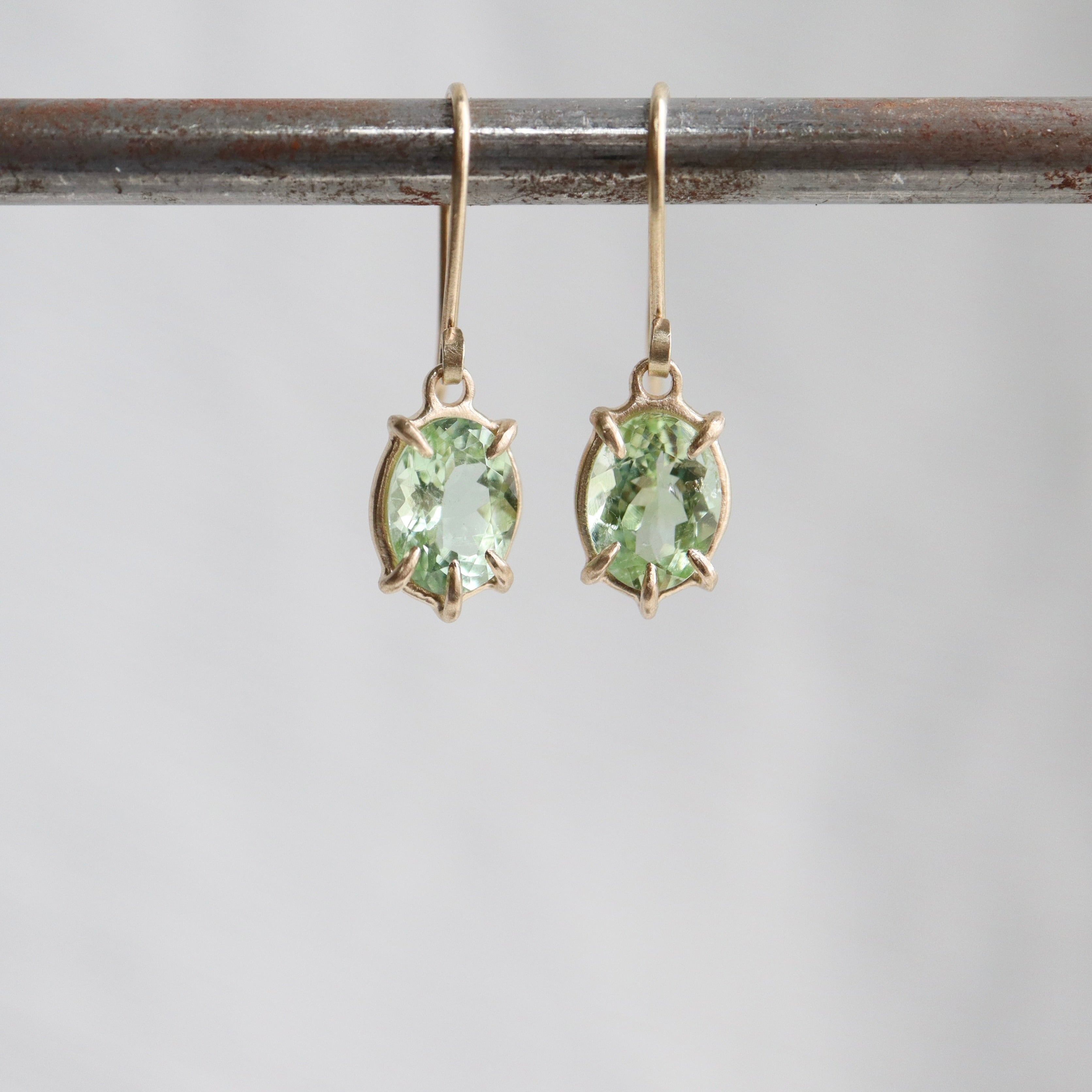 gold prong earrings featuring oval green tourmaline gemstones