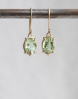 gold prong earrings featuring oval green tourmaline gemstones