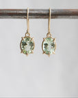 gold prong earrings featuring pale green tourmaline oval gemstones