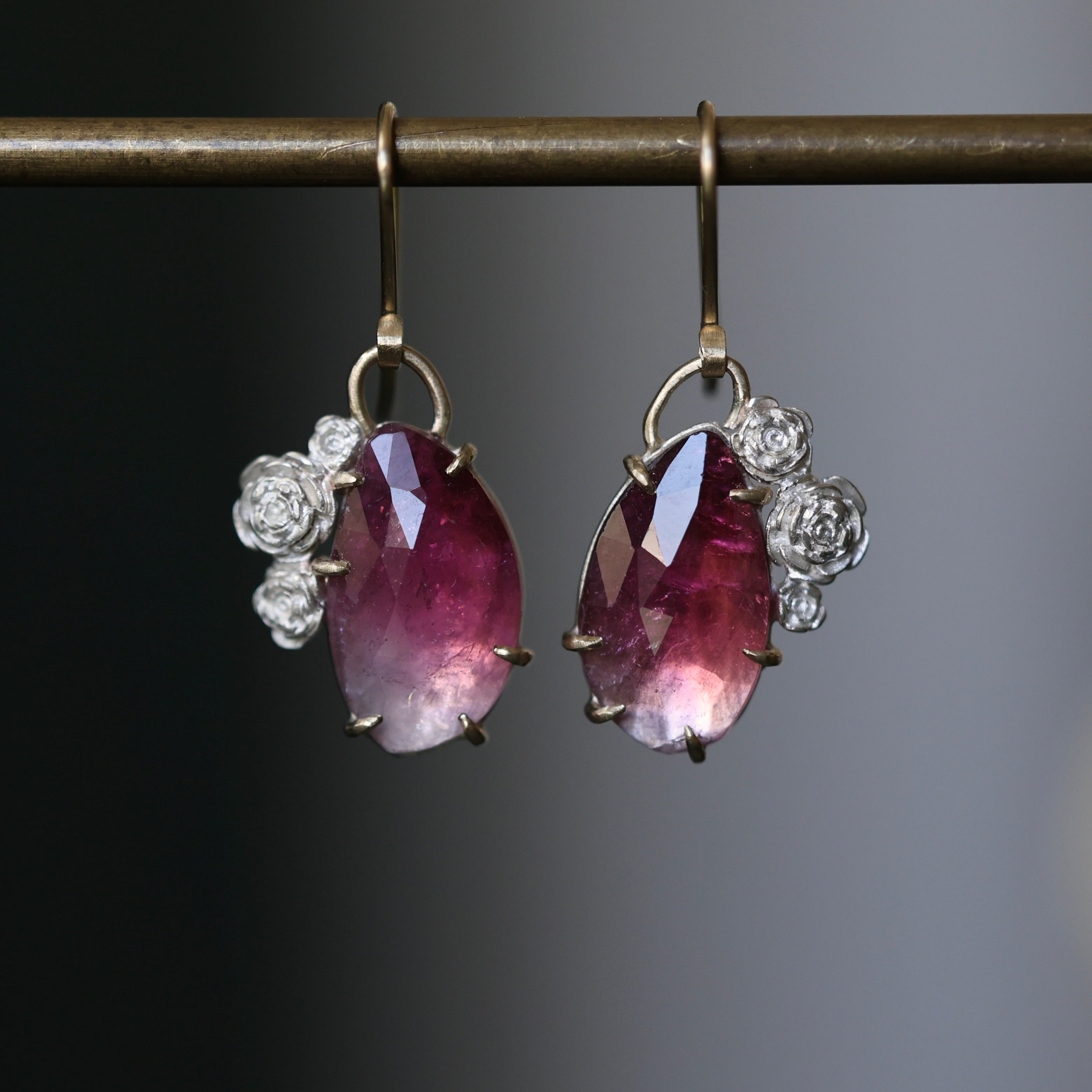 Ombre pink tourmaline earrings with 14k yellow gold prongs, ear wires, and bails. Cradled by bright sterling silver stone seats and rose accents. 