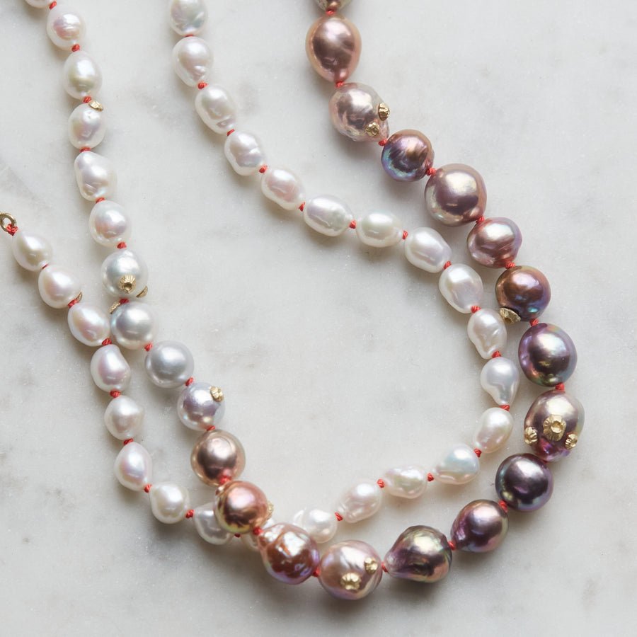 detail of pink and white freshwater baroque pearl necklace in ombre pattern with gold barnacles and fish hook clasp and coral silk by hannah blount jewelry
