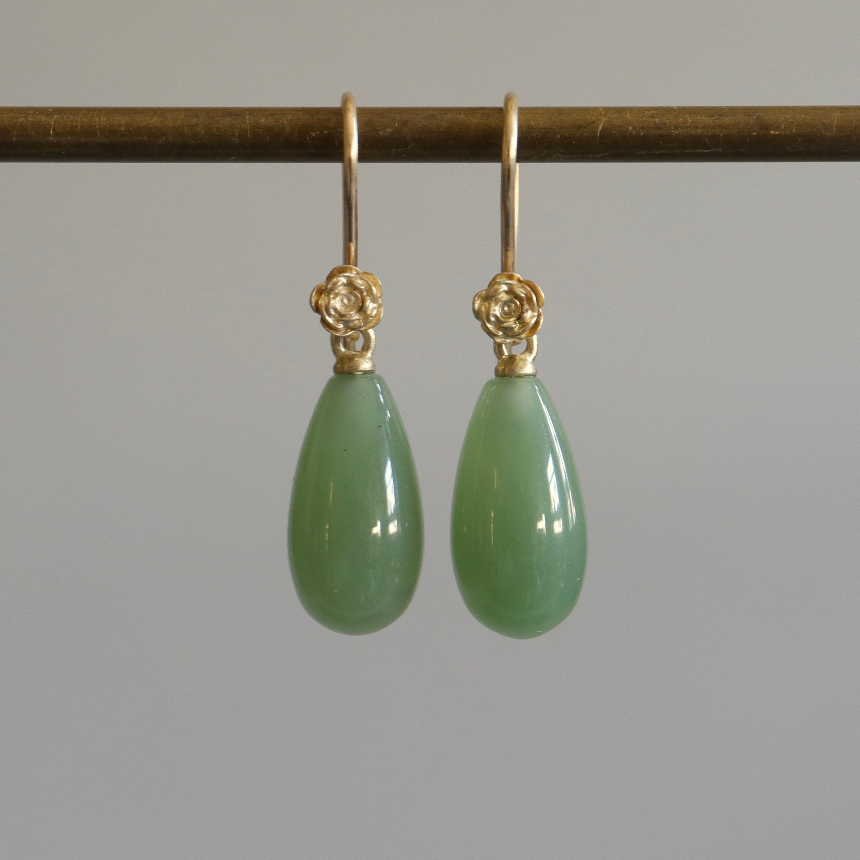 sage green nephrite jade teardrops hang beneath gold rose ear wires