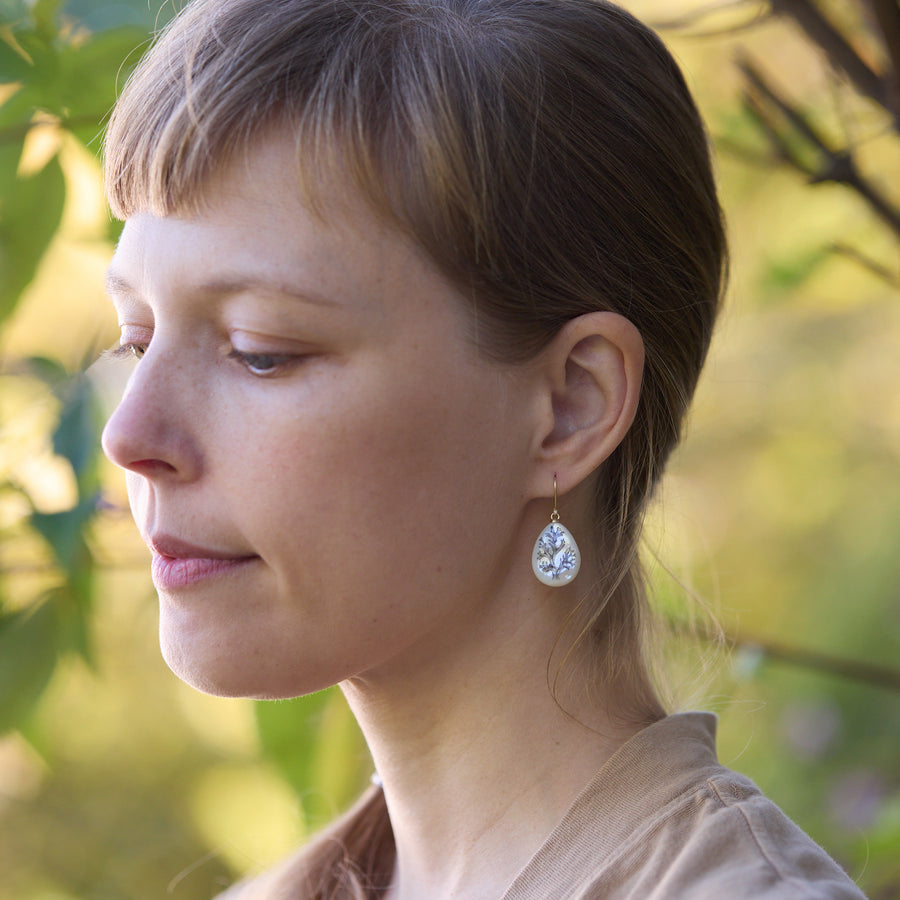 Woman wearing earrings with a blurred natural background