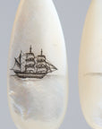 Teardrop-shaped mismatched earrings, a ship design on one and a mermaid on the other. 