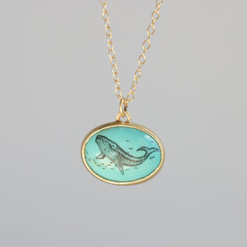Necklace with a pendant featuring a whale design on a gray background