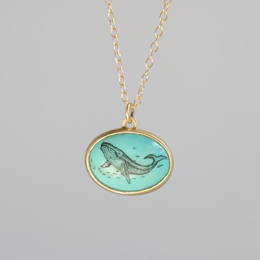 Necklace with a pendant featuring a whale design on a gray background