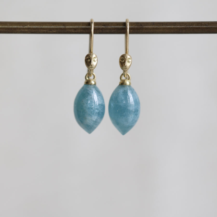 Pair of blue teardrop earrings with gold hooks on a white background