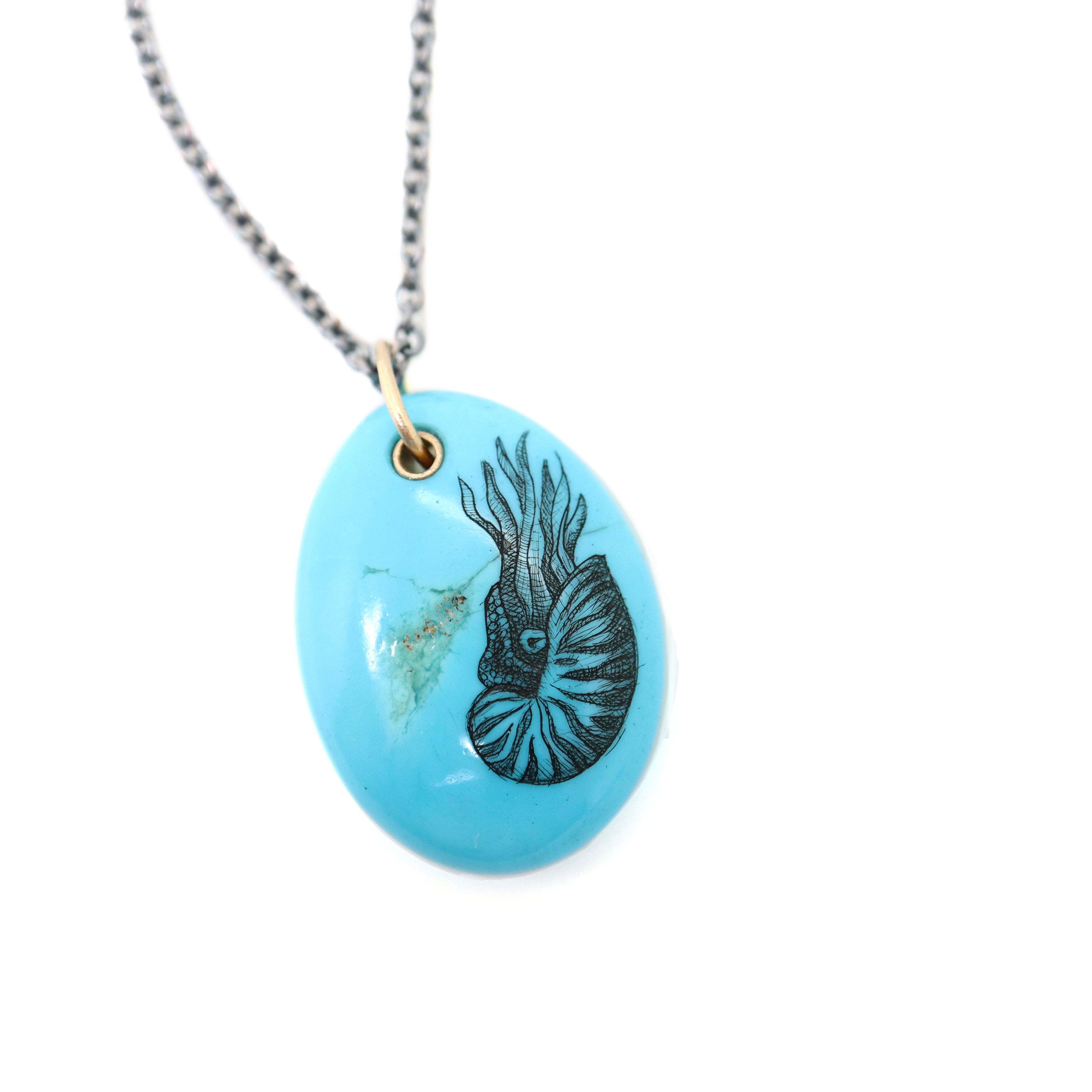 kingman turquoise pendant with inked illustration of a nautilus on oxidized silver chain with gold details