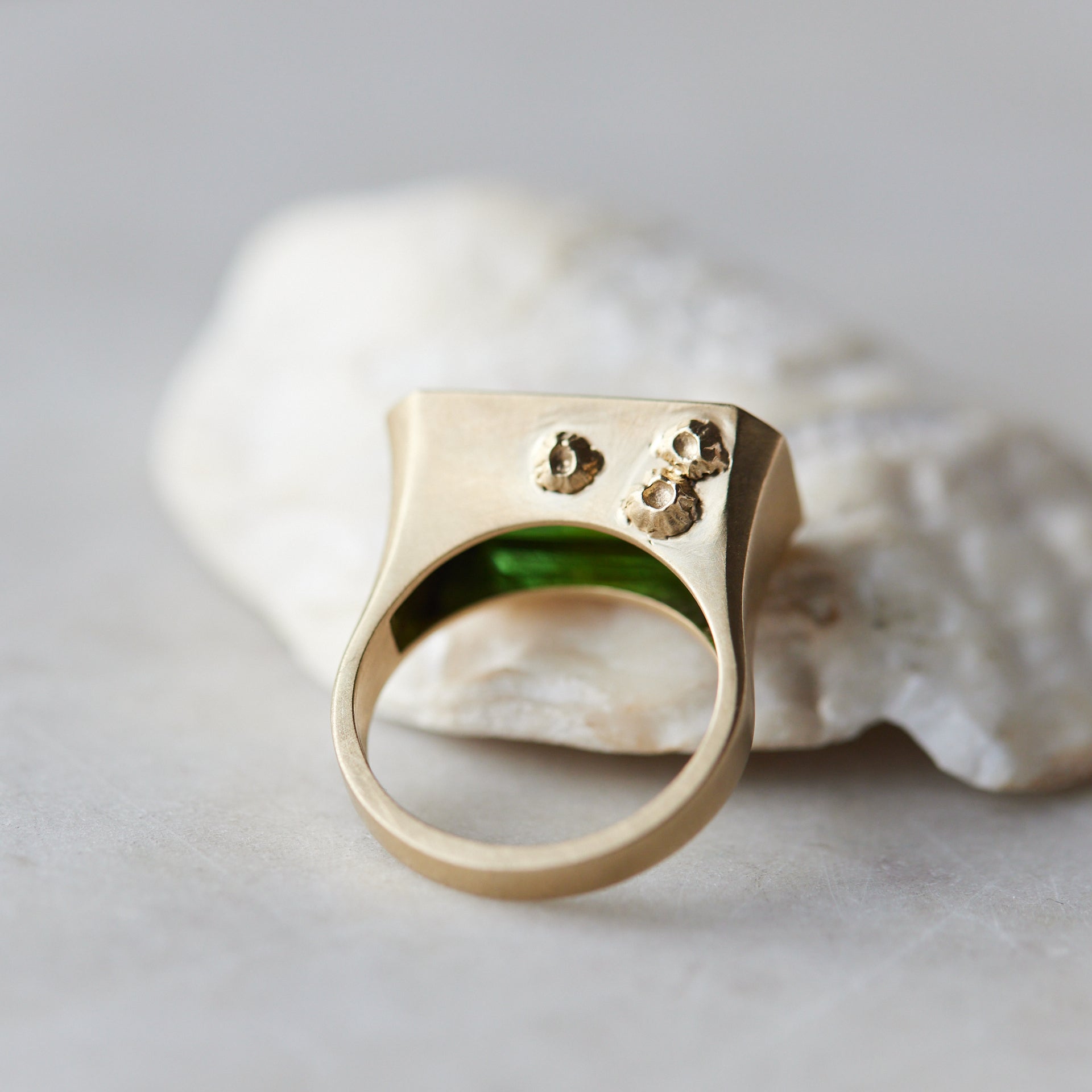 green tourmaline rectangle cut stone ring set in gold with barnacles- back side