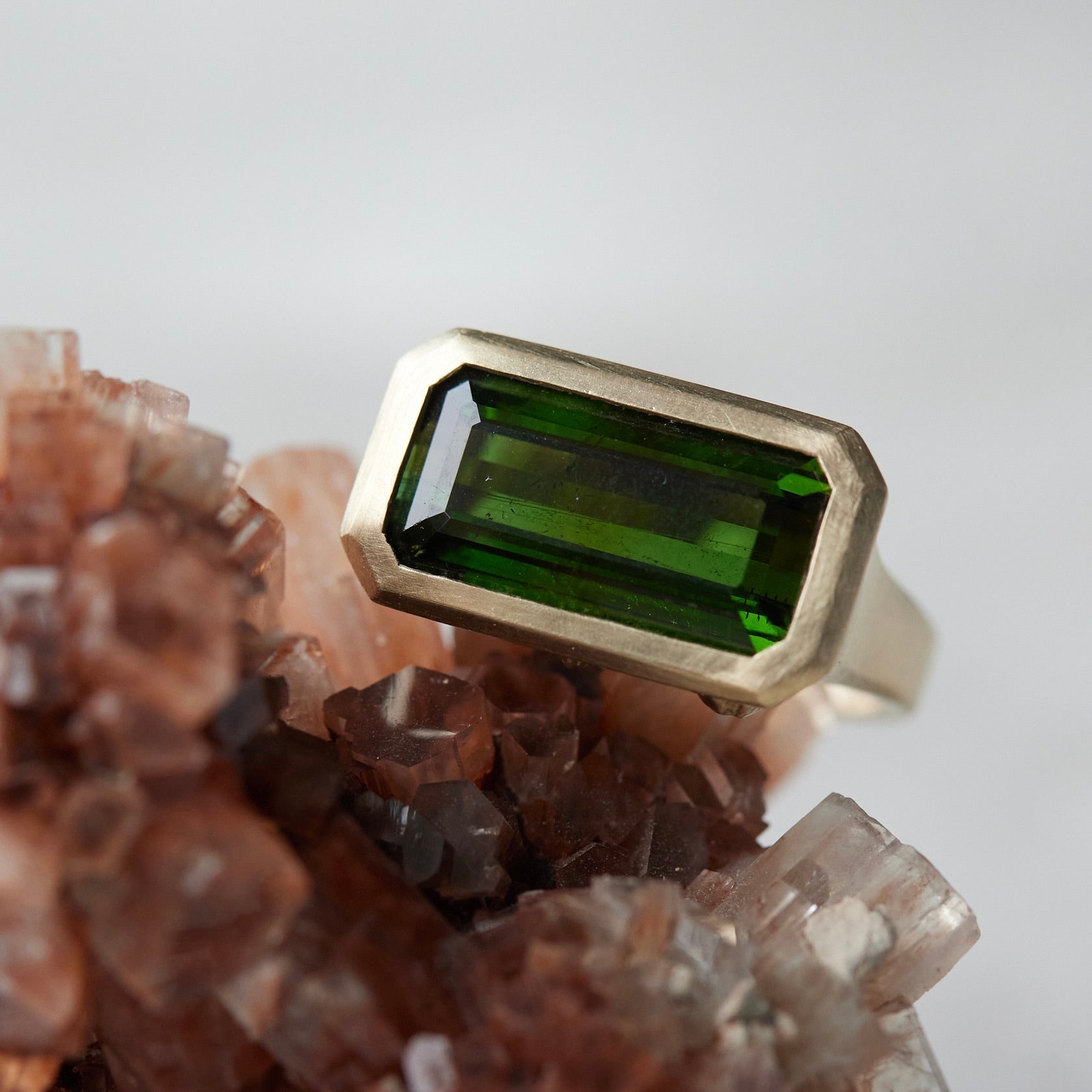green tourmaline rectangle cut stone ring bezel set in 14k yellow gold with barnacles
