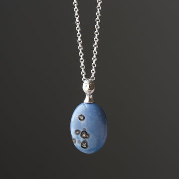 mottled blue common opal set under a silver lady pendant
