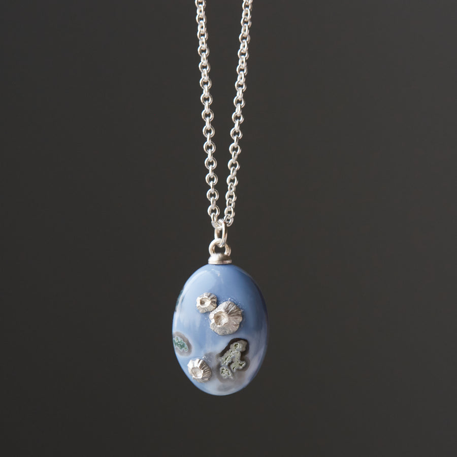 mottled blue common opal pendant with silver barnacles on a silver chain
