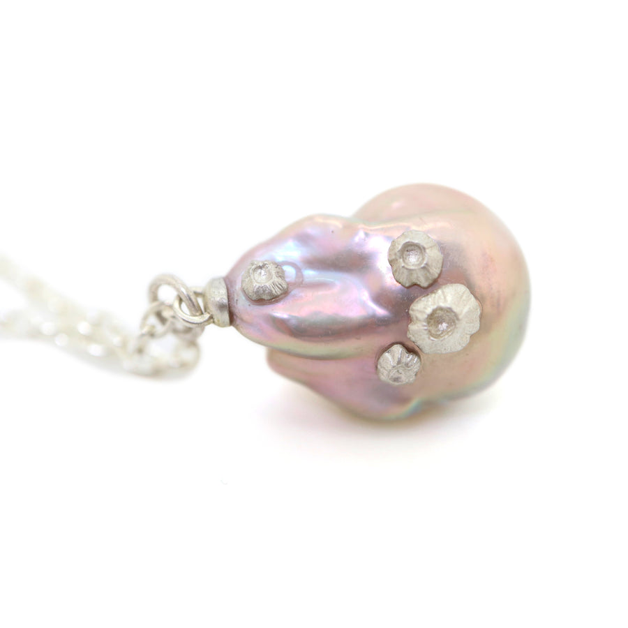 detail of large pink baroque freshwater pearl pendant with silver barnacles on long silver chain by hannah blount jewelry