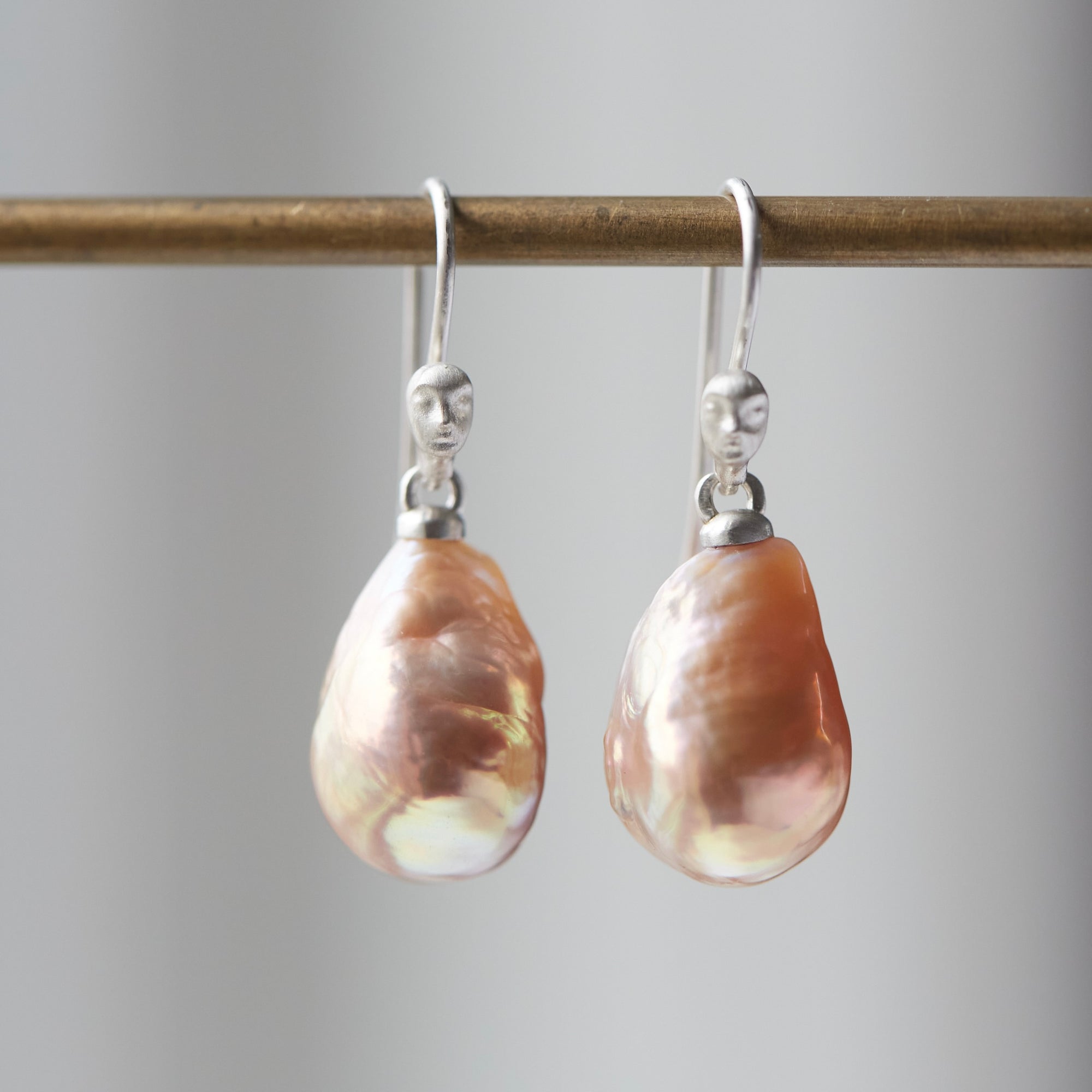 peach freshwater baroque pearl drop earrings with silver ear wires with cameo faces by hannah blount jewelry