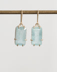 Bright blue stones suspended from gold ear wires