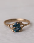 Gold ring with a blue gemstone on a light fabric background