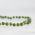 Green beaded necklace on a white background