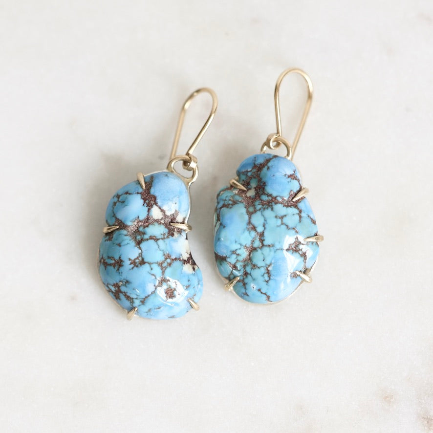 Marbled turquoise earrings held in gold prongs