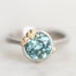 Platinum bezel set aquamarine ring with gold barnacle accents.