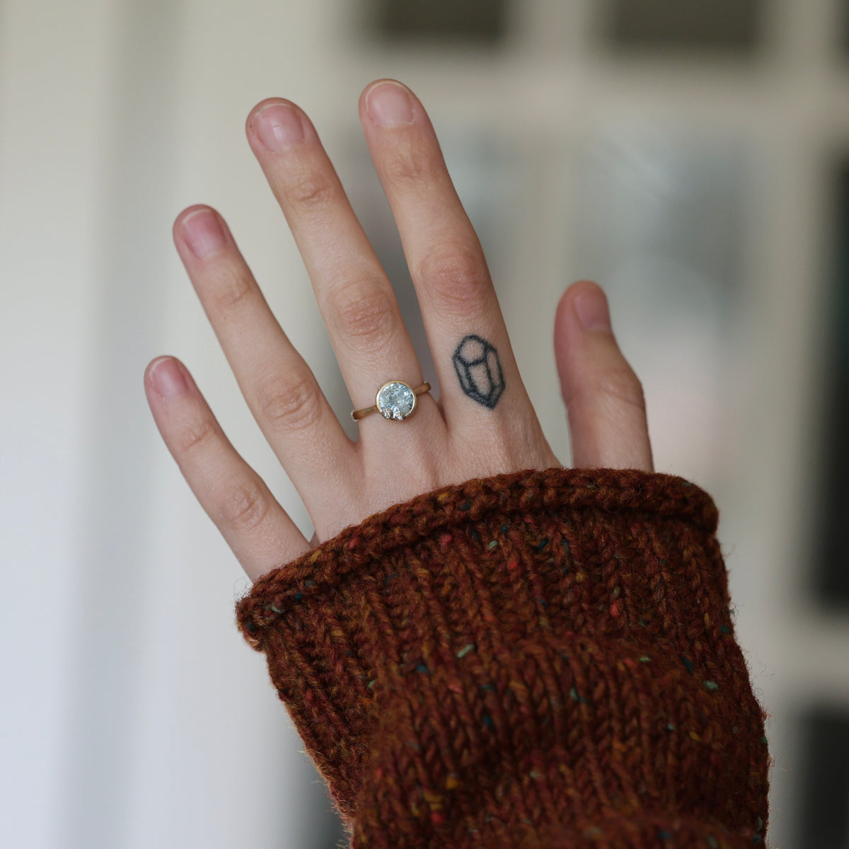 Hand wearing aquamarine ring.