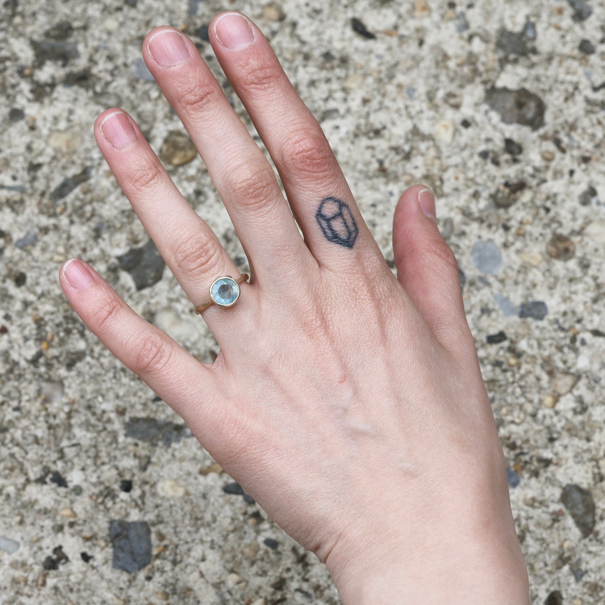 Gold aquamarine ring on hand