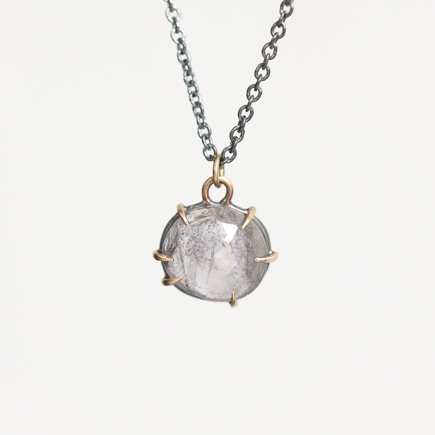 Purple spinel necklace hung from oxidized chain with gold prongs