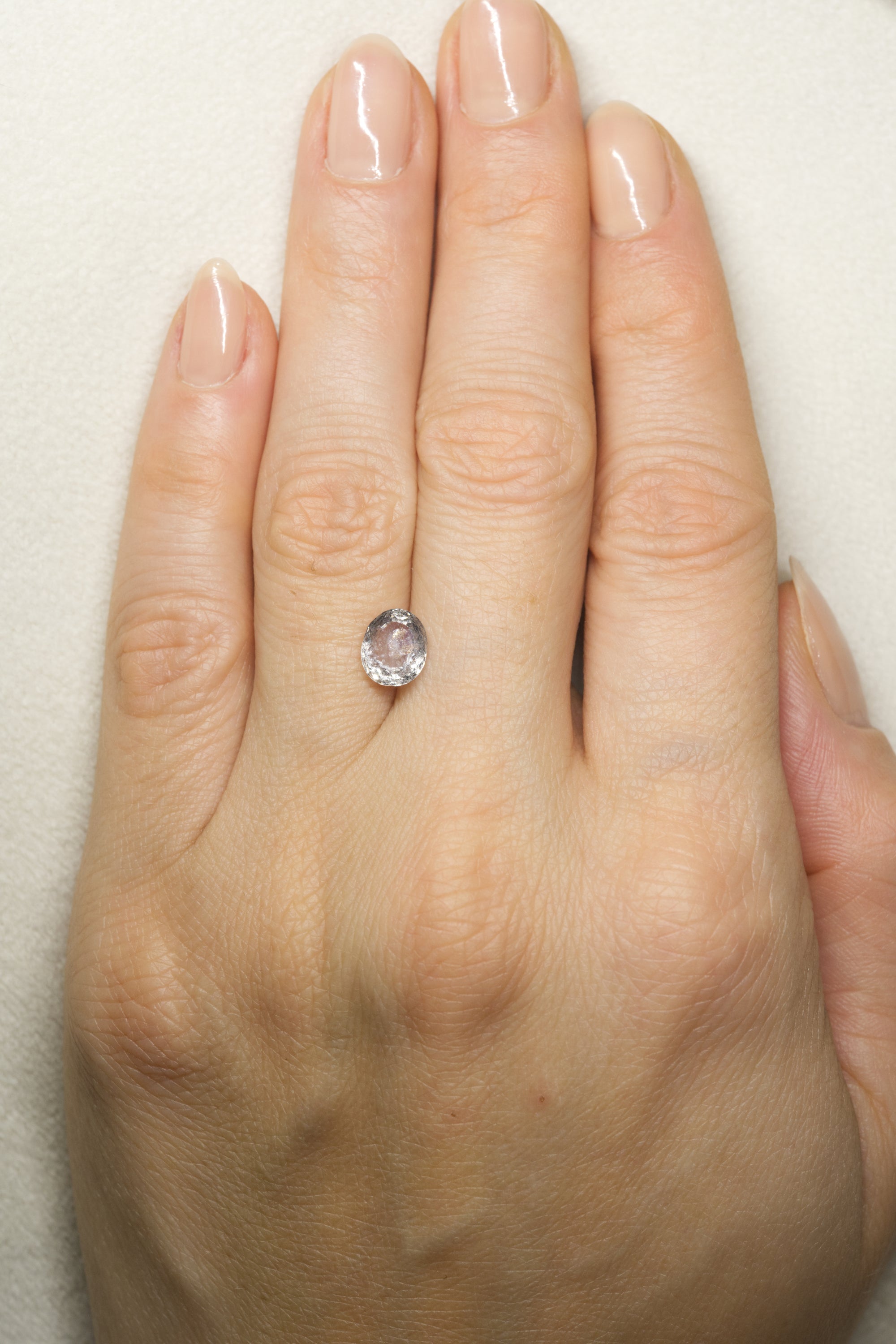 1.835 White Montana Sapphire on hand for scale