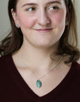 Woman wearing green stone necklace