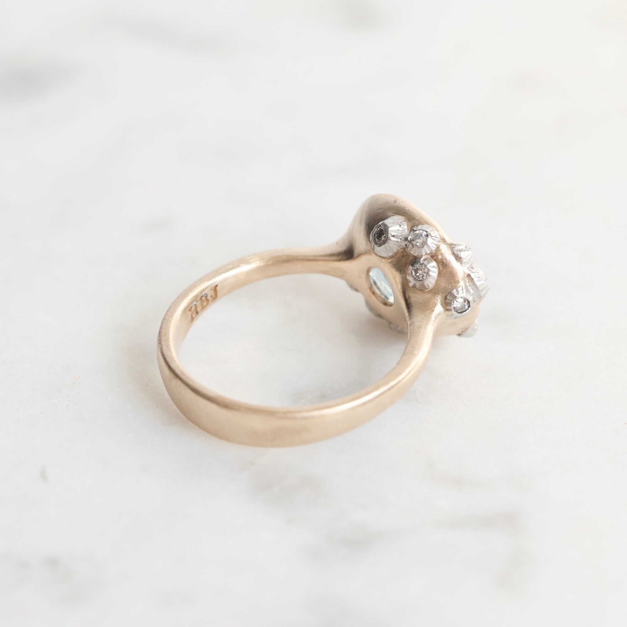 Gold ring with a diamond on a light gray background
