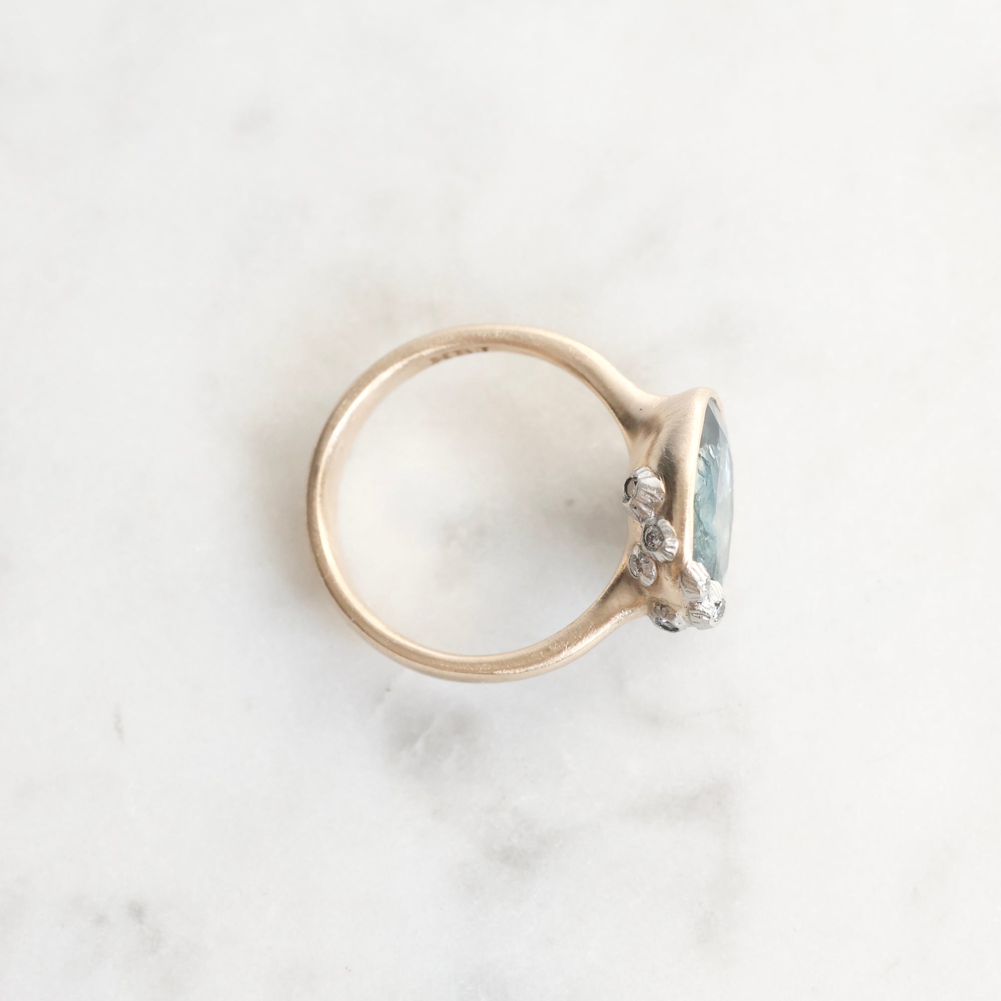 Silver ring with a gemstone on a marble surface