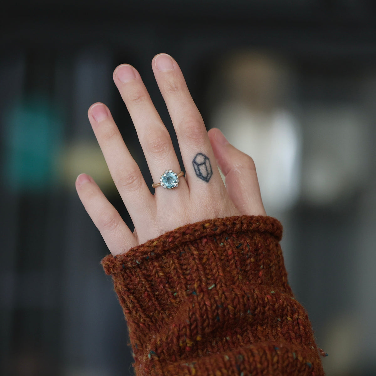 Hand wearing large aquamarine gemstone ring. 