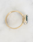 Gold ring with a green gemstone on a white background