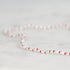 Necklace with red and white beads on a light gray background