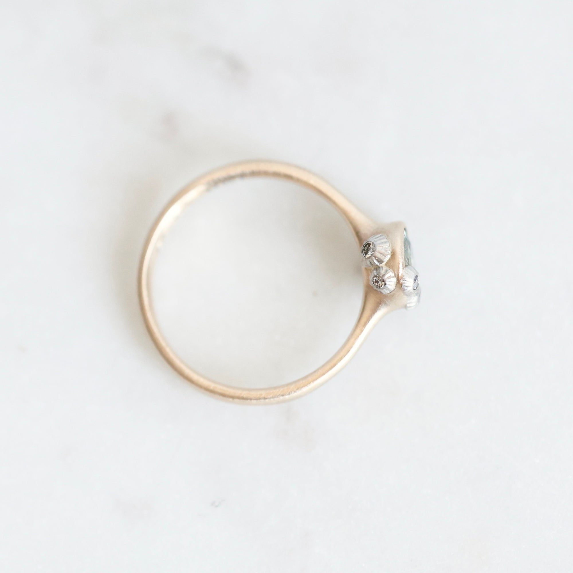 Top view of sapphire bezel set ring. Platinum barnacles with tiny diamonds set in them visible