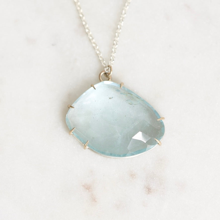 Blue topaz necklace laying on marble 