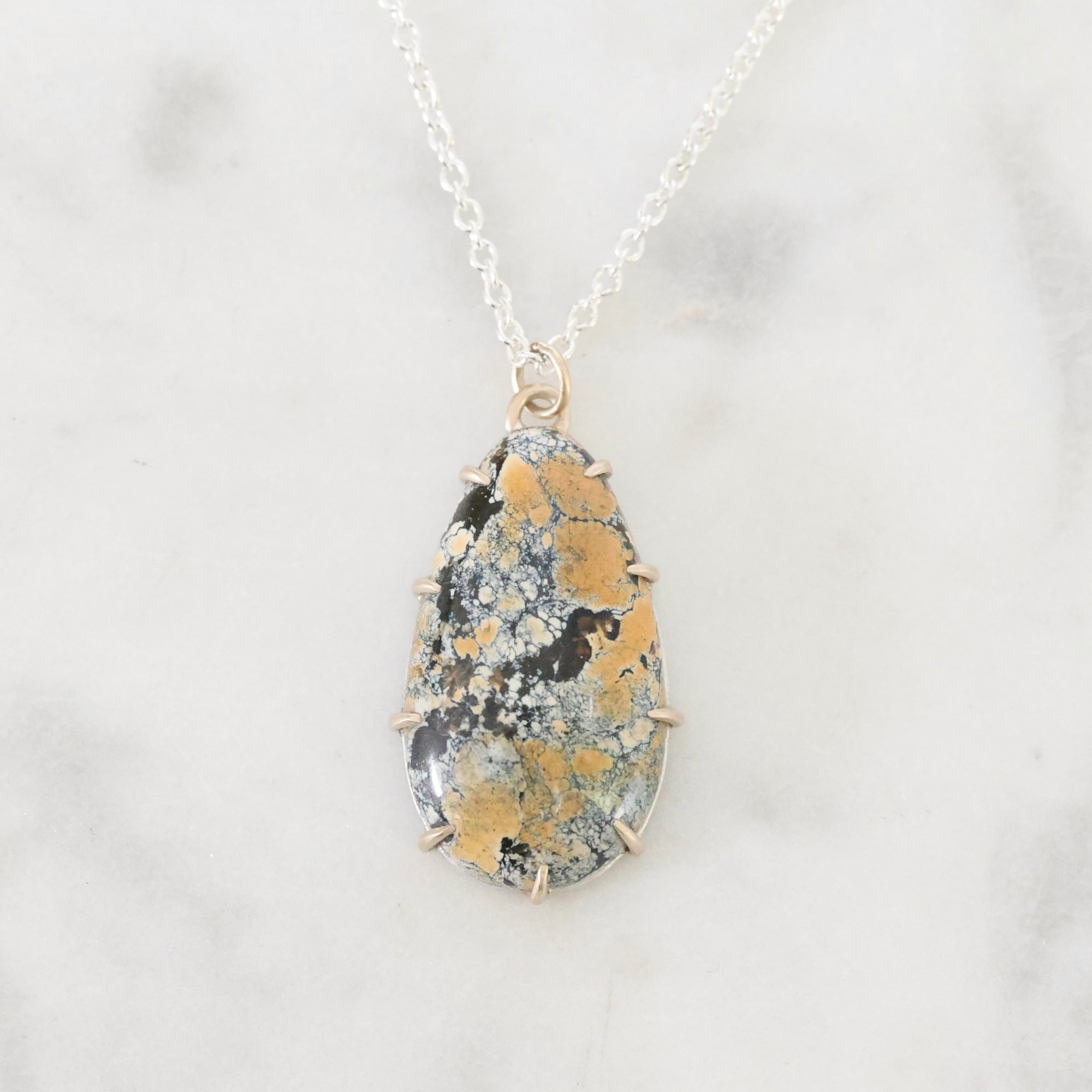 Necklace with a teardrop-shaped pendant on a light gray background
