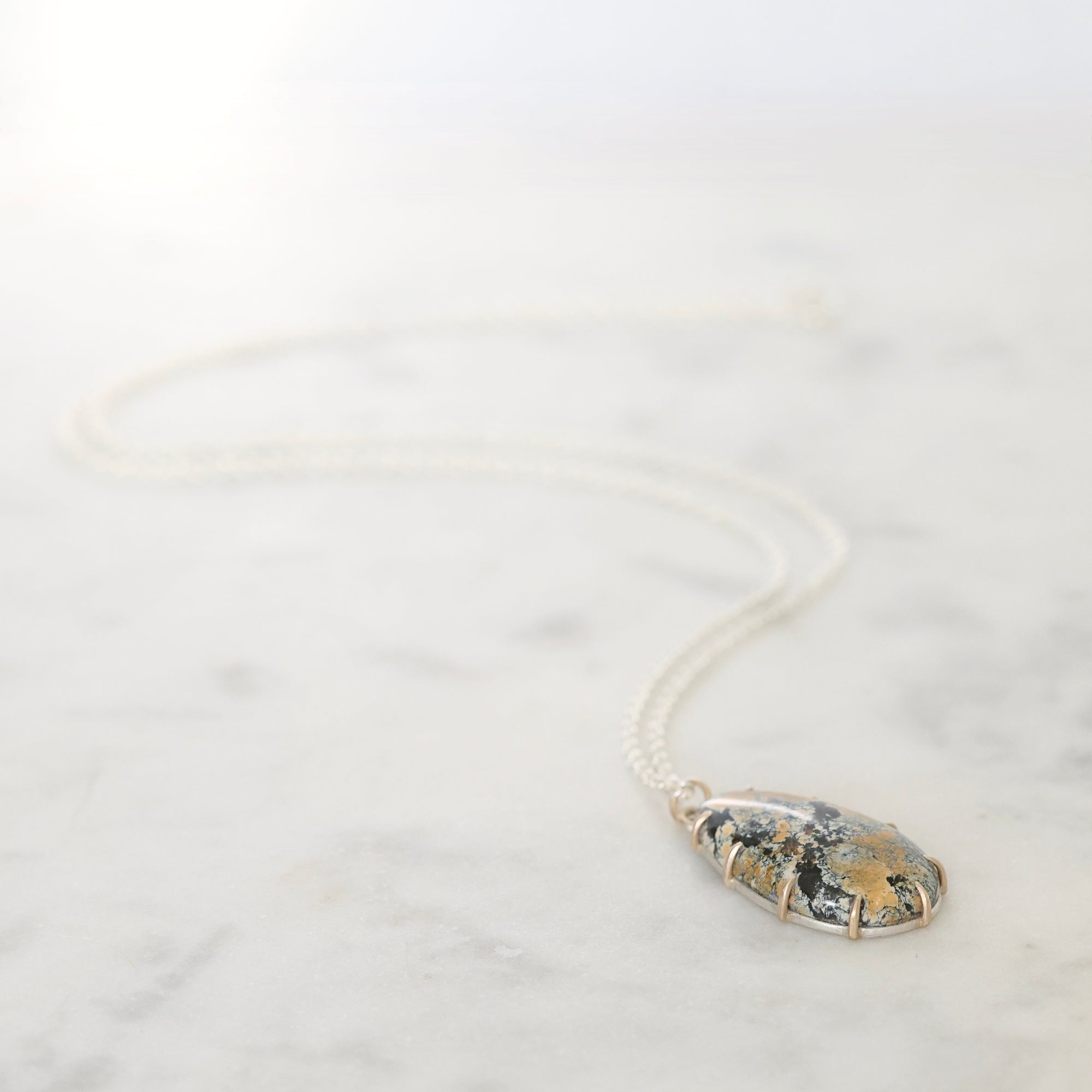 Necklace with a pendant on a white marble surface