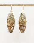 Pair of earrings with marbled green and brown stones on a white background