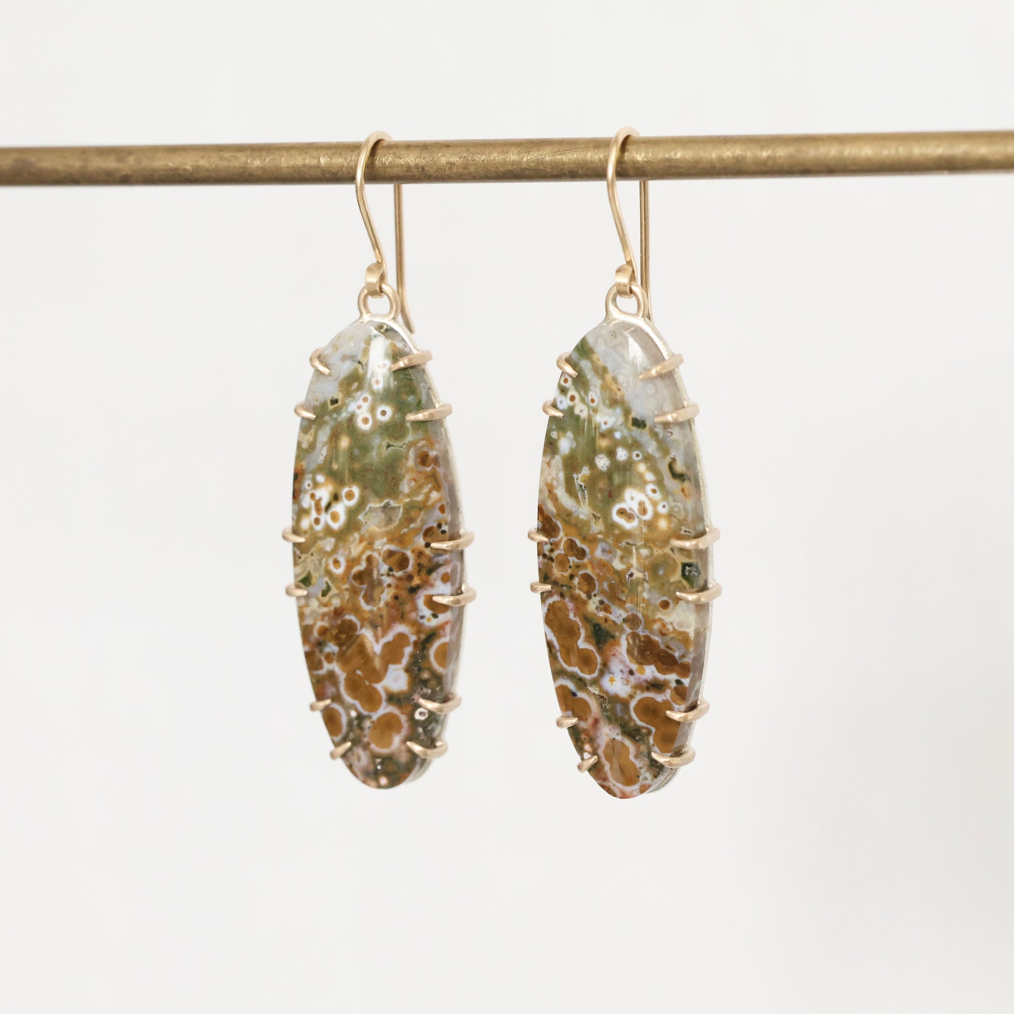 Pair of earrings with natural stone design on a white background