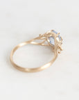 A gold ring with a small light blue gemstone, photographed on a plain white background.